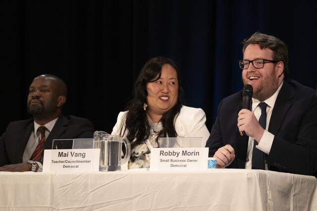 Robby Morin, right, speaks during a congressional candidate forum for CA District 7 at Coloma Center in Sacramento on Thursday, April 2, 2026, as candidates, from left, Ralph Nwobi and Mai Vang listen.